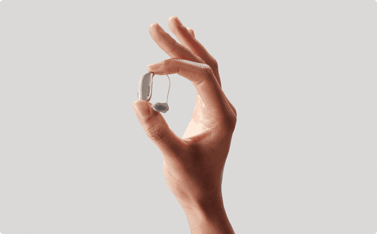 Compact ReSound Sensia receiver-in-ear hearing aid held between two fingers