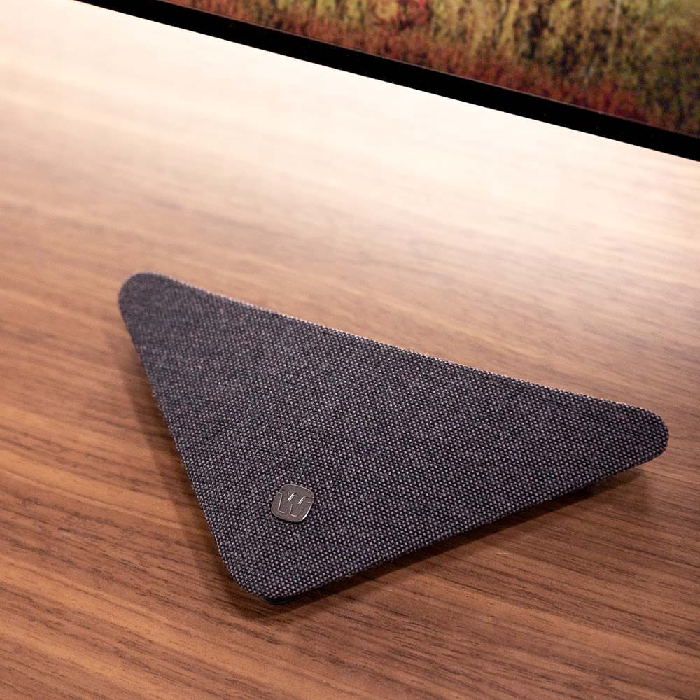 Widex TV Play 2 accessory for Allure and Moment Sheer hearing aids, shown on a table with compact design and control buttons.
